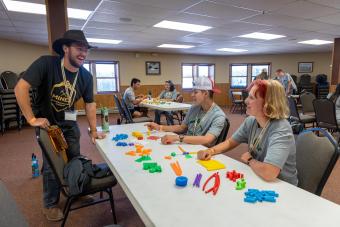 two students sit at a table covered in bright plastic blocks