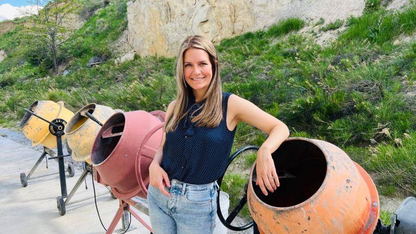 Lori Tunstall poses by concrete mixers
