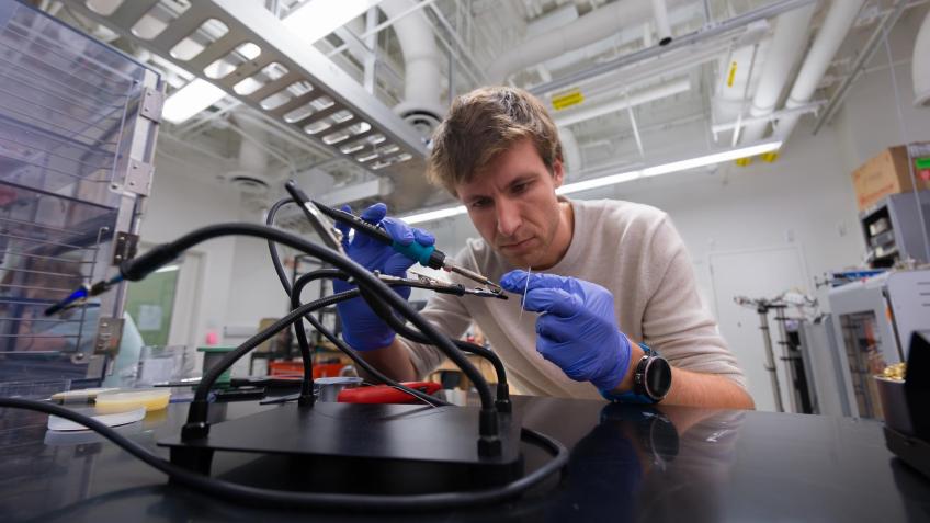 Wouter Van De Pontseele wears blue gloves while assembling wiring on some equipment 