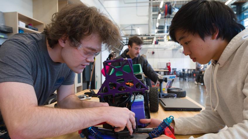 two male students work on rc car