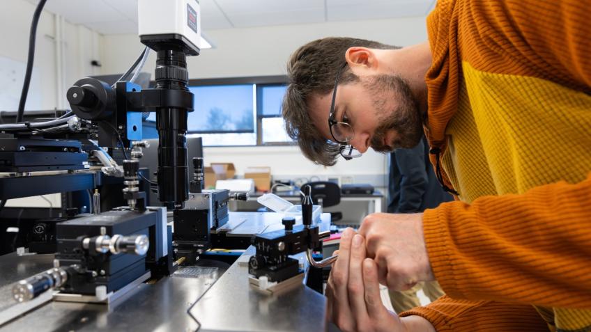 male student works on photonic chip