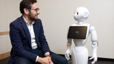 Assistant Professor Tom Williams with a robot