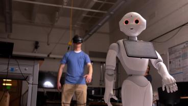 Student works with a humanoid robot in Xiaoli Zhang's lab