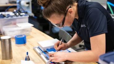 Student Bri Treffner works in the Machine Shop on RockSatX project