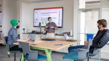 Instructor speaks to two students in McNeil Hall