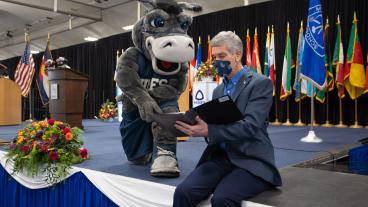 President Johnson sitting on stage with Blaster