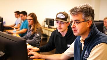 Paul Sava, right, works with a student during a Linux lab class