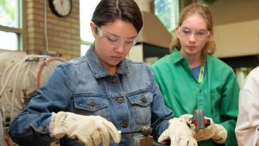 Girl pours metal in the Mines foundry