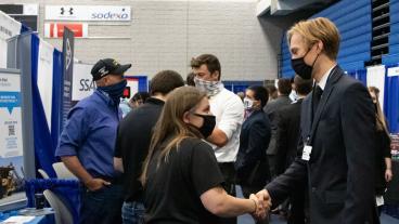 Mines student shakes hand with recruiter at Career Day