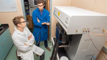 Mike McGuirk talks to student in lab