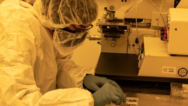 Graduate student Matt Tennery prepares a silicon sample for photolithography in the clean room on campus."
