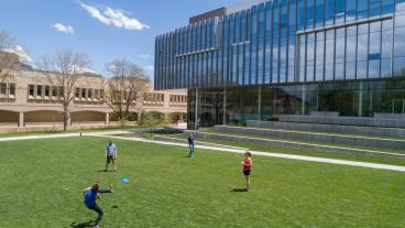 Students play frisbee on Kafadar Commons