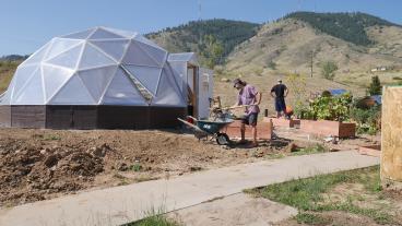 Student works outside next to Mines Greenhouse