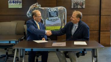 Officials from Mines and University of Regina shake hands