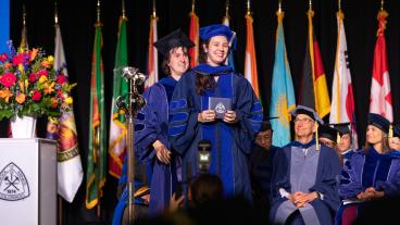 Female PhD student during hooding ceremony at Spring Commencement