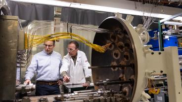 Rob Braun and Neal Sullivan look at a fuel cell in the lab