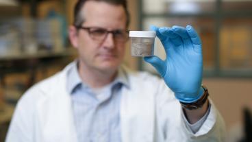 Chris higgins holds a pfas sample