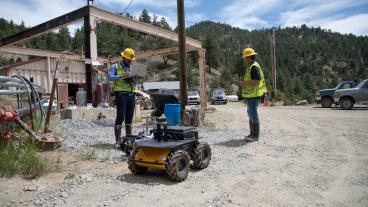 Students work with robot outside Edgar Mine