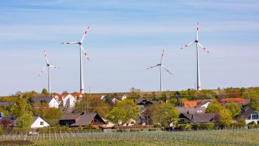 wind turbines in background with homes in foreground