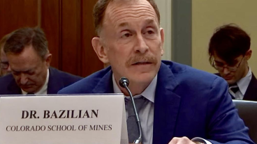 Morgan Bazilian speaking at a table