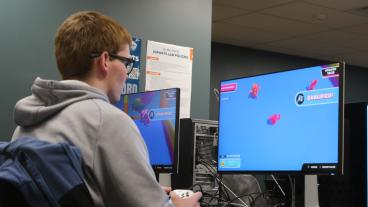 male student plays computer game in esports lab