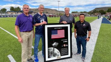 President Johnson, Paul Anderson and others pose with Orion artifacts on football field