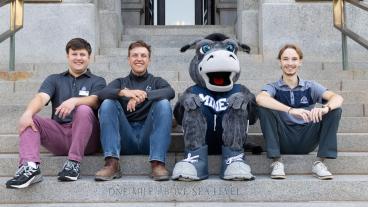 three mines students sit on the state capitol steps with blaster