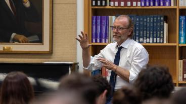george saunders talks in front of library books