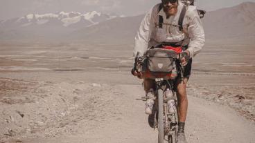 Peter Consalvi riding a bike in a desert