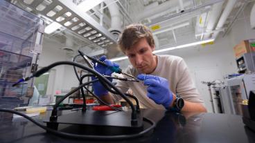 Wouter Van De Pontseele wears blue gloves while assembling wiring on some equipment 