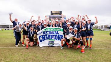 team shot of mines women's rugby team with championship banner
