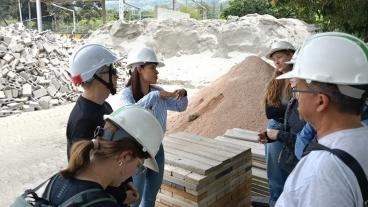 students in hardhats tour sustainable construction facility in Colombia