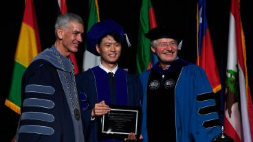 Xue Wang holding Rath plaque with President Johnson and VP Copan