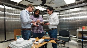 Paulo Cesar Tabares Velasco and graduate students Andy Gloor and Quin Guy inspect an indoor air quality data acquisition system in the AMBER Lab at Mines