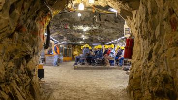 students wearing yellow hardhats sit in a classroom inside a mine