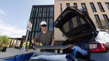 Patrick Miko unloads his skateboard and belongings during move-in day at Lookout Apartments.