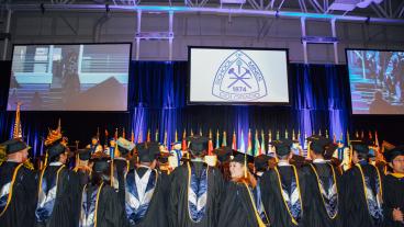 Mines graduates prepare to walk across the stage at commencement ceremony