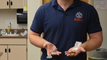 Metallurgical and Materials Engineering doctoral student Joseph Grogan holds galvanized steel in one hand and ferrous steel and zinc in the other.