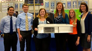 Members of the team, Turnip the Beet, hold a model of the food hub they designed. 