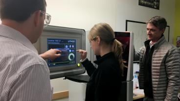 Shawn Allan, vice president of Lithoz America, shows the CeraFab 7500 printer to Mines graduate student Sarah Sortedahl and ADAPT Industry Director Craig Brice. 