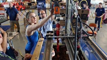 Mines student Caroline Ellis works on her team's water extraction system as Research Associate Professor Angel Abbud-Madrid looks on at the 2017 NASA Mars Ice Challenge.