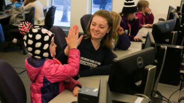 Female student works with a young girl