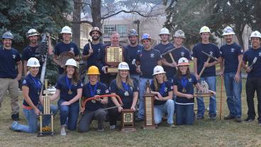 Mines President Dr. Bill Scoggins poses with the Mines teams after the event