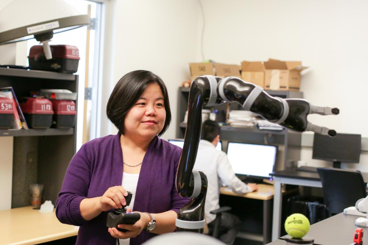 Xiaoli Zhang operates a robotic arm in a lab at Mines