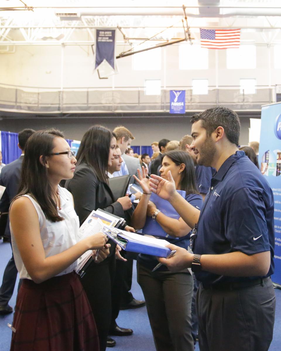 Mines female student talks to a recruiter at the Fall 2016 Career Day.